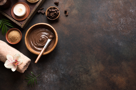 Chocolate Spa flat lay on dark background, top view, copy space. Natural chocolate spa beauty products with towel and plants.の写真素材
