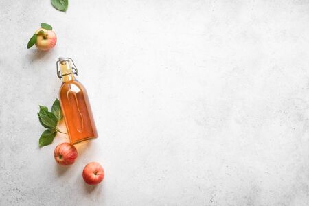 Apple cider vinegar or fermented fruit drink and organic apples on white, top view, copy space. Healthy eating and lifestyle concept.の写真素材