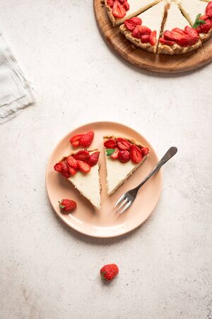 Cheesecake with fresh strawberries for dessert - healthy organic summer berries dessert cheesecake, copy space, top view. Homemade cheese cake.の写真素材