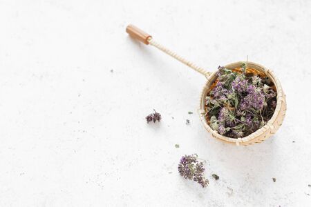 Herbal Tea on white background, top view, copy space. Tea stainer with dried oregano and lavender flowers, natural herbal tea composition.の写真素材