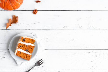 Pumpkin spice or carrot layered cake with cream cheese frosting on white, top view. Homemade dessert for Halloween and Thanksgiving - seasonal autumnal pumpkin cake.の写真素材