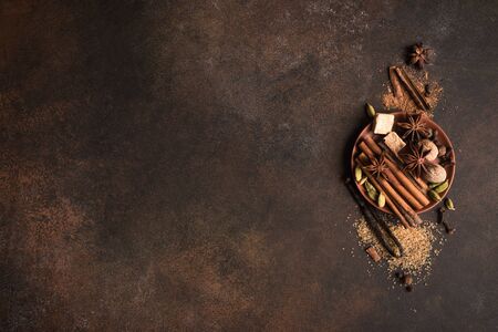 Winter Spices and Brown Sugar on dark rustic background, top view, copy space. Mulled wine or...