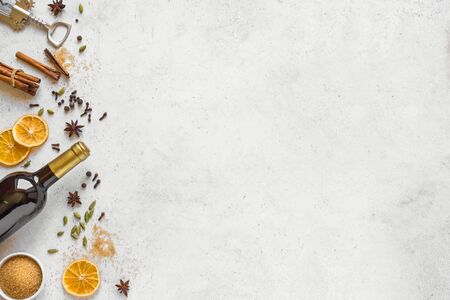 Winter Spices for Mulled Wine on white background, top view, copy space. Seasonal mulled wine ingredients - aroma spices and bottle of red wine.の写真素材