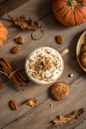 Pumpkin Spice Latte. Cup of Latte with Seasonal Autumn Spices, Cookies and Fall Decor. Traditional Coffee Drink for Autumn Holidays.の写真素材