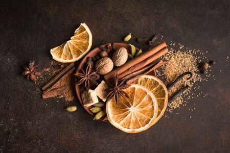 Winter Spices and Brown Sugar on dark rustic background, top view, copy space. Mulled wine or...