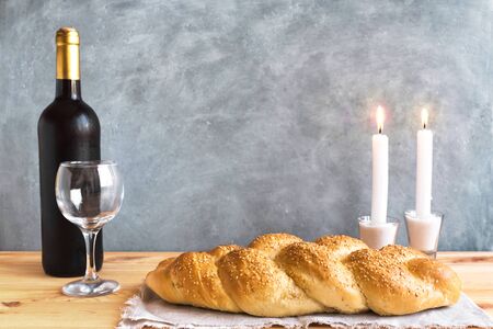 Shabbat or Shabath concept. Challah bread, shabbat wine, book and candles on table, copy space. Traditional Jewish Shabbat ritual.の写真素材