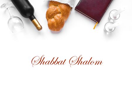 Shabbat or Shabath concept. Challah bread, shabbat wine, book and candles  isolated on white, top view, copy space. Traditional Jewish Shabbat ritual.の写真素材