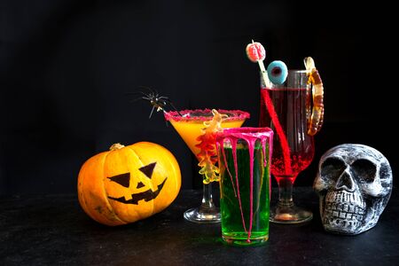 Halloween Cocktails - pumpkin spice martini, green and bloody red drinks. Festive Halloween cocktails assortment and decor for party, copy space.の写真素材