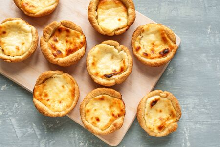 Portuguese custard tarts Pastel de Nata. Traditional Portuguese pasties for breakfast on blue...