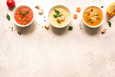 Soup Assortment. Set of various seasonal vegetable soups and organic ingredients, top view, copy space. Homemade colorful vegan vegetarian soups.の写真素材
