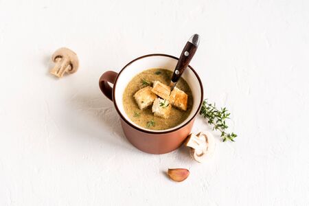 Mushroom Soup. Homemade champignons cream soup with croutons in enamel mug. Healthy and comfort food concept, copy space.の写真素材