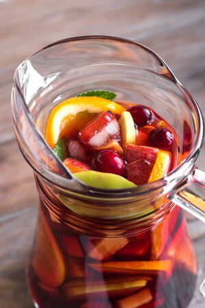 Red wine sangria or punch with fruits and ice in pitcher. Homemade refreshing fruit sangria close up.の写真素材
