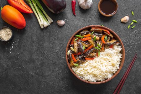 Stir fried eggplant and bell pepper and rice on white, top view, copy space. Asian chinese food. Vegan healthy meal and ingredients.の写真素材