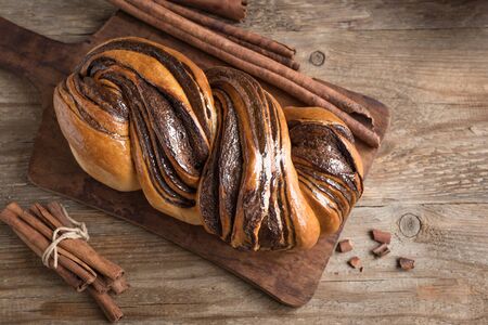 Cinnamon Babka or Brioche Bread. Pumpkin swirl bread, homemade pastry for breakfast, wooden background, top view, copy space.の写真素材