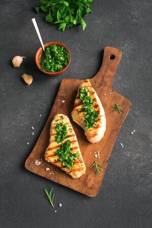 Grilled Chicken or Turkey Breast with green Chimichurri Sauce, copy space, banner. Homemade Chicken or Turkey Breast Steak with fresh herbs.の写真素材