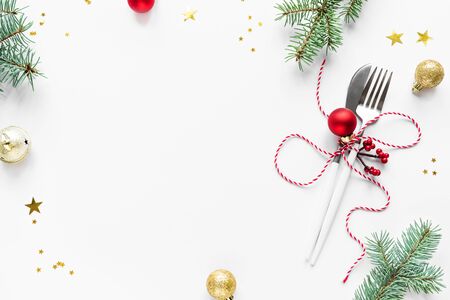 Christmas Table Setting with fir branch and red ornaments on white, flat lay, copy space. Christmas dinner, party design, concept - table setting with festive decoration.の写真素材