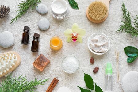 Natural Skin Care and Spa Set on white soft towel background with natural cosmetic products, flower, green leaves, candle and zen like stones. Relax concept, top view, flat lay.の写真素材