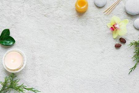 Natural Skin Care and Spa Set on white soft towel background with natural cosmetic products, flower, green leaves, candle and zen like stones. Relax concept, top view, flat lay.の写真素材