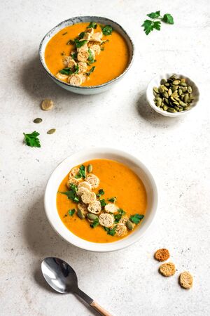 Vegetable Soup topped with croutons and parsley in bowl on white background, top view, copy space. Healthy seasonal diet vegetarian food - homemade soup.の写真素材