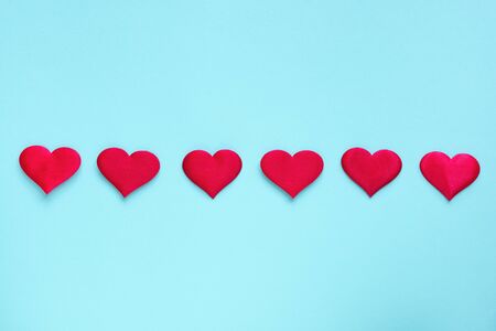 Valentine's Day background. Red hearts in row on pastel blue background, copy space. Valentines day,...