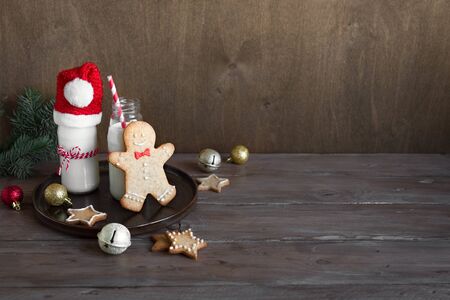 Christmas composition with Gingerbread cookies and milk on wooden background, copy space. Cookies and milk for Santa.の写真素材