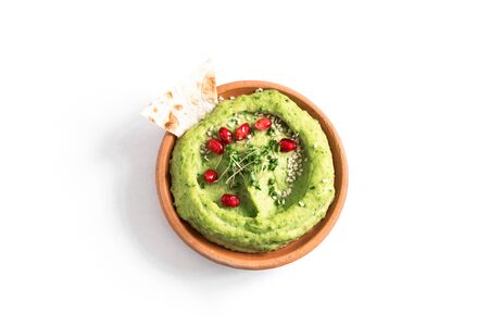 Green Avocado Hummus bowl, healthy vegan dip. Organic green herbal, spinach hummus,  spread  with pita bread isolated on white. Top view, copy space.の写真素材