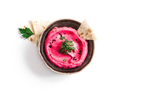 Red Beetroot Hummus bowl, healthy vegan dip. Traditional Middle eastern beet hummus,  spread  with pita bread and vegetables isolated on white. Top view, copy space.の写真素材