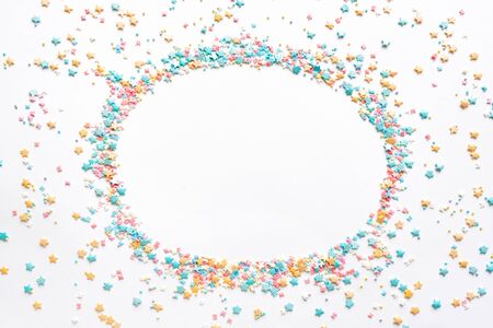 Colorful Sugar Sprinkles on white background, top view, round copy space. Sweet cake pastry ingredient, holiday birthday concept, creative layout.の写真素材