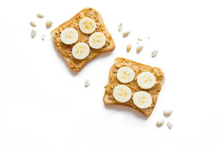 Slice of  toast bread with peanut butter and banana  isolated on white, top view, copy space. Sweet...