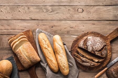 Fresh Bread on wooden background, top view, copy space. Homemade fresh baked various loafs of wheat...