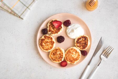 Cottage cheese pancakes  (syrniki, curd fritters) for breakfast. Fresh homemade cheese pancakes on white background, top view, copy space.の写真素材