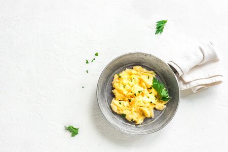 Scrambled Eggs on pan for healthy breakfast or brunch, top view, copy space. Homemade  meal recipe - scrambled eggs on white background.の写真素材