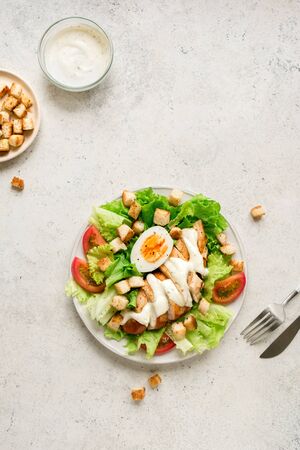 Caesar salad with chicken breast on white background, top view, copy space. Fresh chicken salad for healthy lunch.の写真素材