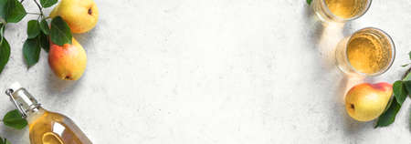 Pear cider drink or fermented fruit drink  in glasses and bottle and organic pears on white, top view, copy space. Healthy homemade hard pear cider, banner.の写真素材