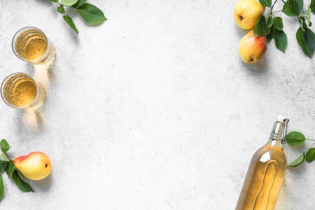 Pear cider drink or fermented fruit drink  in glasses and bottle and organic pears on white, top...