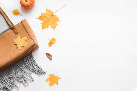 Autumn composition - warm plaid, suede bag, autumn leaves on white background, flat lay, top view,...