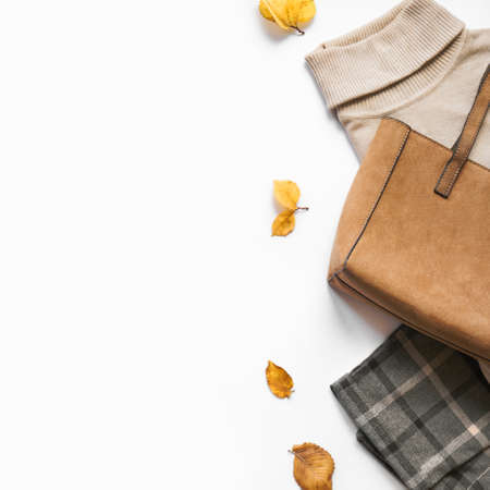 Autumn Clothes Set with autumn leaves on white, top view, copy space. Stylish and cozy seasonal female outfit.の写真素材
