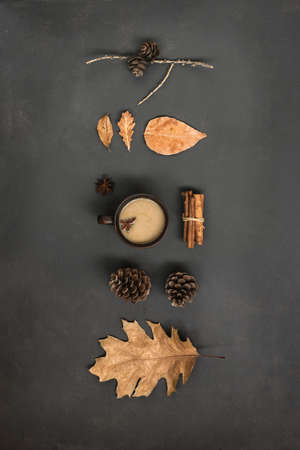 Autumn Leaves and cup of hot drink creative flat lay. Fall Background. Dried leaves, pine cones and...