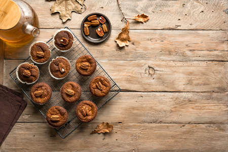 Autumn Breakfast. Homemade Pumpkin Spice Muffins with Pecan nuts, top view, copy space. Fall seasonal baking.の写真素材