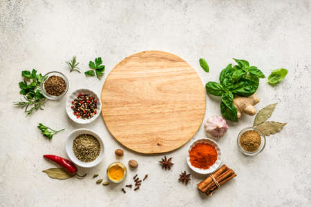 Various Spices, Herbs and Condiments around plate on white stone table, top view, copy space. Healthy cooking, indian food background.の写真素材