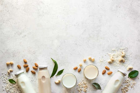 Various vegan plant based milk and ingredients, top view, copy space. Dairy free, lactose free nut and grains milk, substitute drink, healthy eating.の写真素材