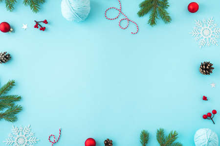 Christmas composition. Christmas decor, pine cones, fir branches and showflakes on blue background. Flat lay, top view, copy space.の写真素材