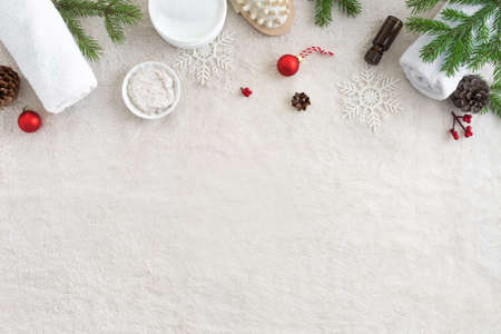 Christmas Spa Concept and Winter Skin Care products, fir branches and snowflakes on white soft towel background, flat lay, copy space. Seasonal beauty routine and skin care concept.の写真素材