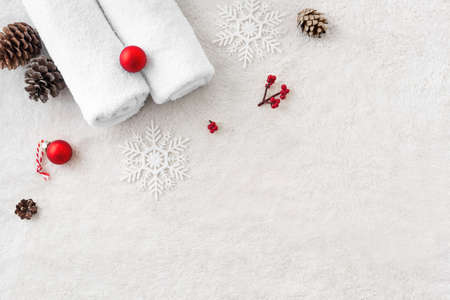 Christmas Spa Concept and Winter Skin Care products, pine cones and snowflakes on white soft towel background, flat lay, copy space. Seasonal beauty routine and body care concept.の写真素材