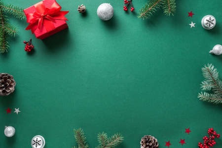 Christmas composition. Christmas decor, gift box, pine branches on dark green background. Flat lay, top view, copy space.の写真素材