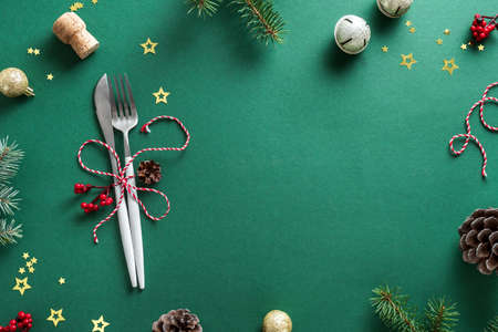 Christmas Table Setting with fir branch and ornaments on green, flat lay, copy space. Christmas...