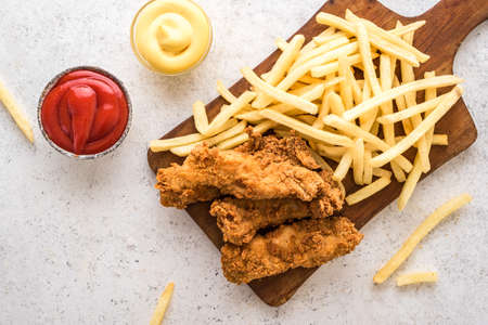 Fish and chips. Deep fried fish filet and with french fries on white background with sauces....