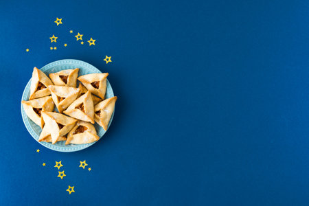 Jewish Purim Hamantaschen biscuits or cookies. Traditional homemade pastry for jewish purim carnival holiday on blue background.の写真素材