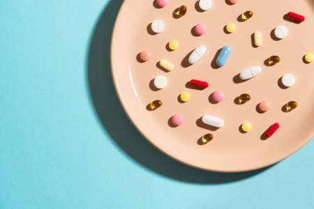 Many various vitamin pills and supplements as food on plate. Nutritional supplements dosage concept....