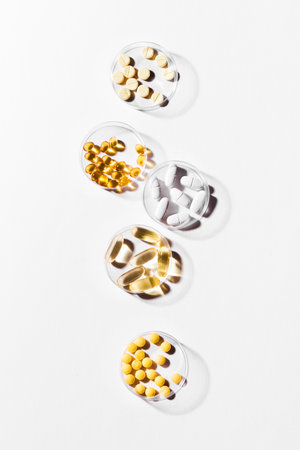 Vitamins capsules on white background, top view, copy space. Food supplements: fish oil, omega 3,...
